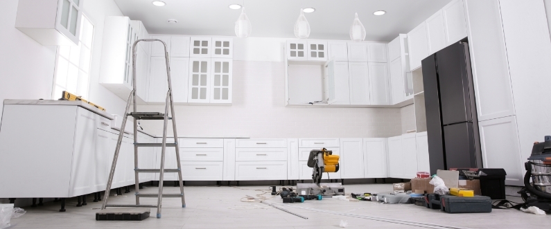 a monochrome white kitchen in the finishing stage of a remodel