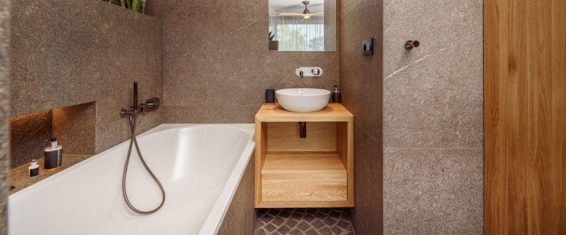 a small bathroom with an alcove tub and neutral tile walls