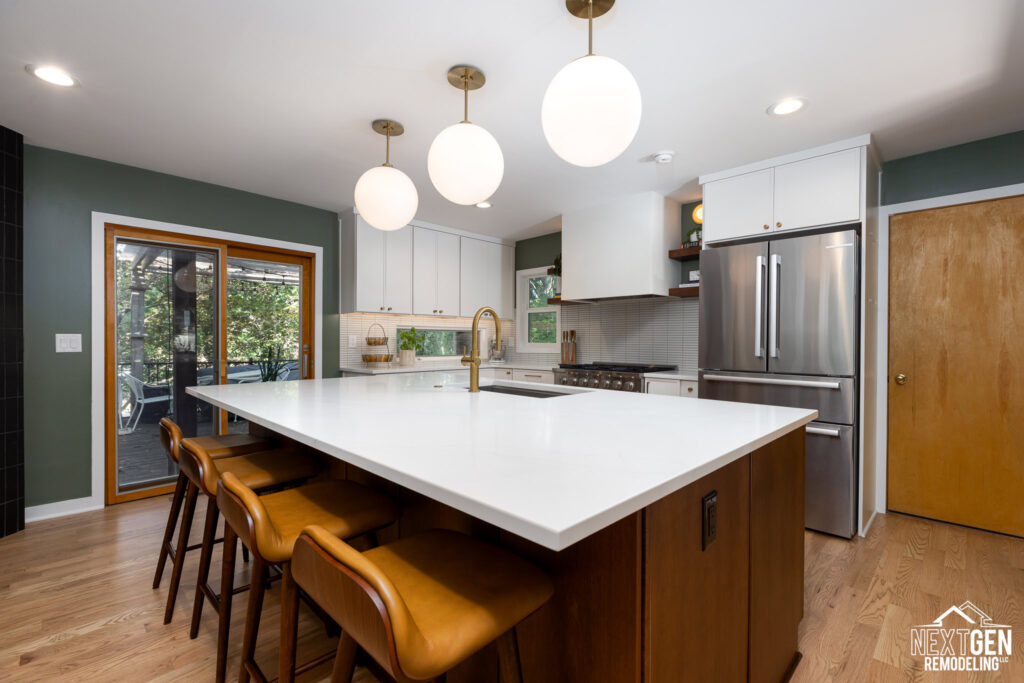 Mid-century kitchen remodel in Kansas City. White perimeter cabinets with rich wood tone island. White quartz countertops and modern pendant lighting